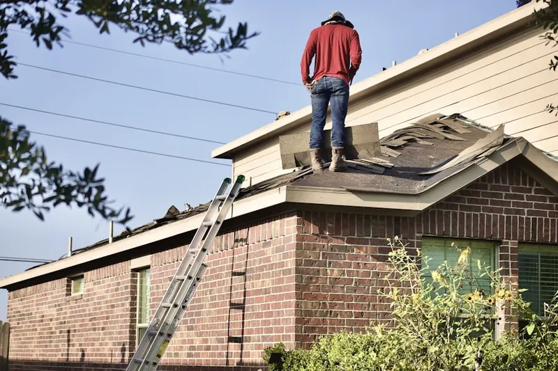 Professional roofer working on a residential roof in West Davis